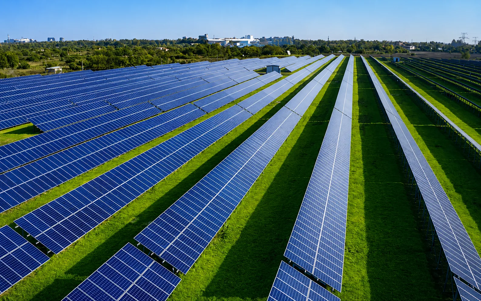 Large solar farm with rows of blue panels and clean green surroundings
